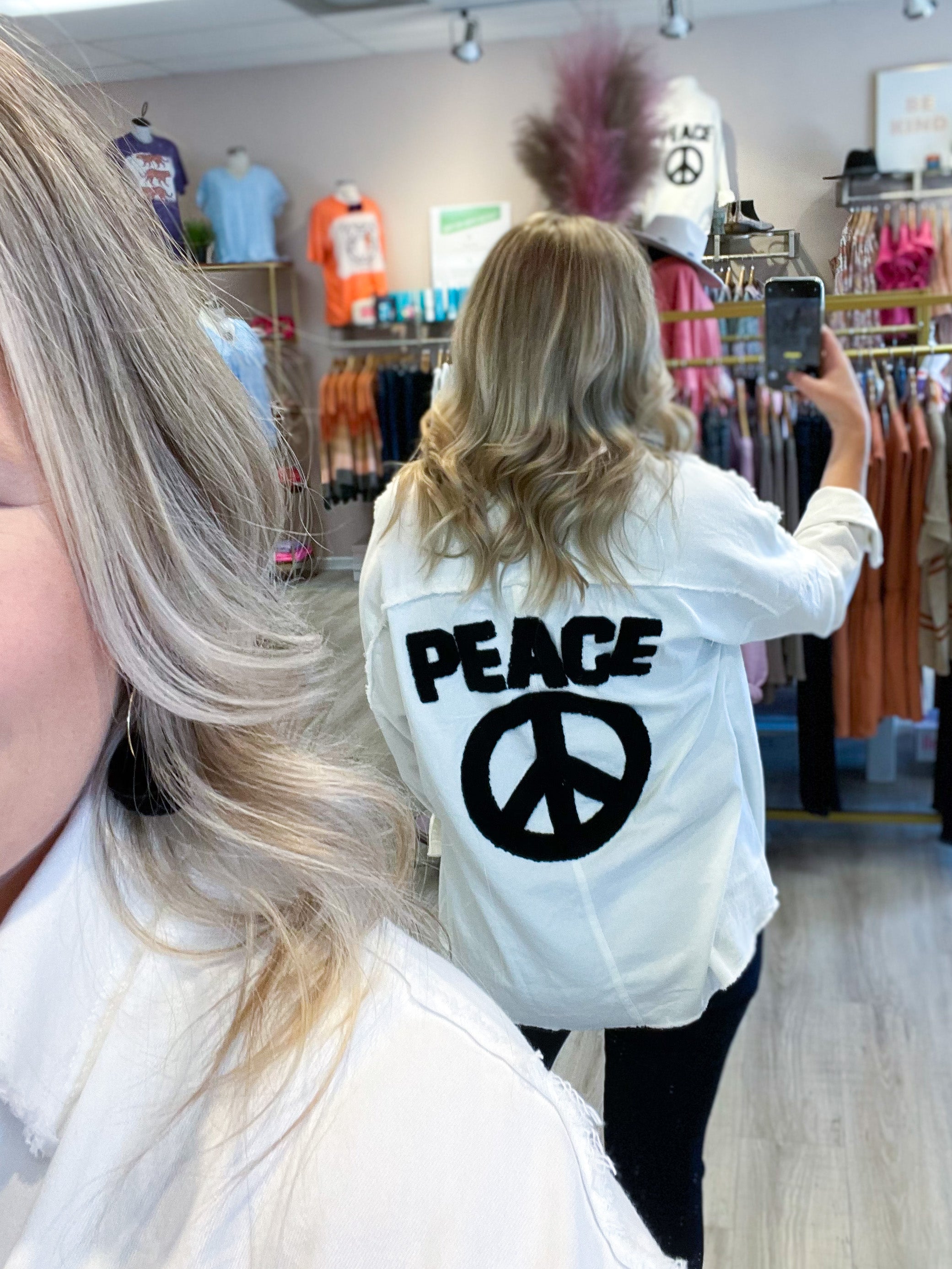 white denim jacket with black peace and peace sign on the back